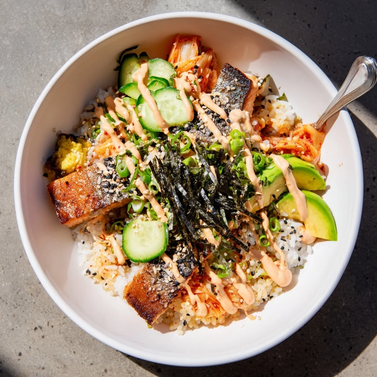 Crispy Salmon Rice Bowl topped with spicy mayo, avocado, and tangy kimchi.  