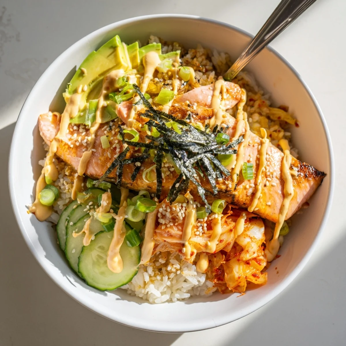 A colorful Crispy Salmon Rice Bowl with crispy garlic, fresh cucumbers, and sesame seeds.  