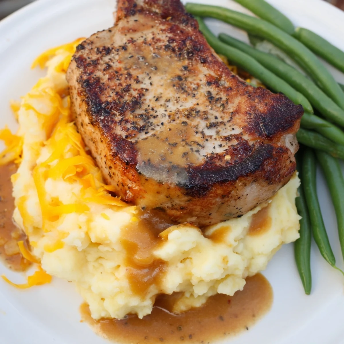 A close-up of a flavorful Pork Chops & Cheddar Mash Bowl, showcasing perfectly cooked pork.