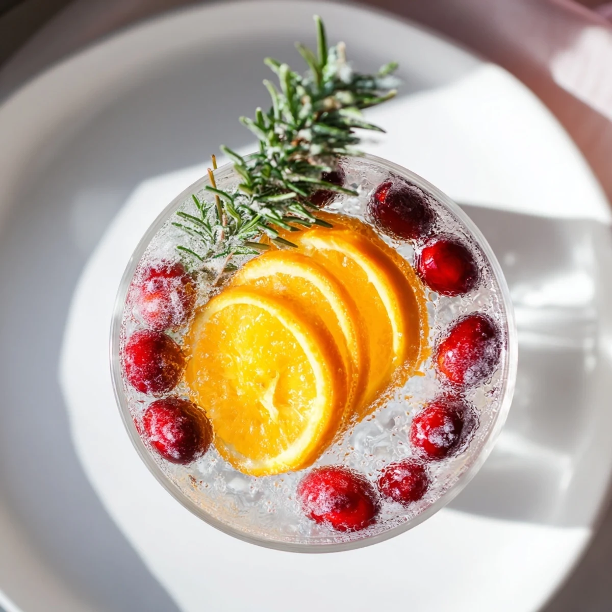 Snow Globe Mocktail with floating cranberries, sparkling and ready to serve at your holiday party.