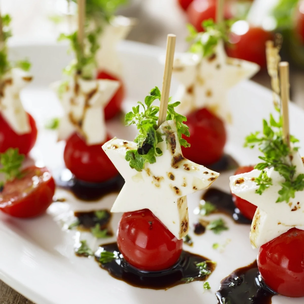 Fresh Caprese Skewers in star shapes: a delicious appetizer drizzled with balsamic glaze and olive oil.