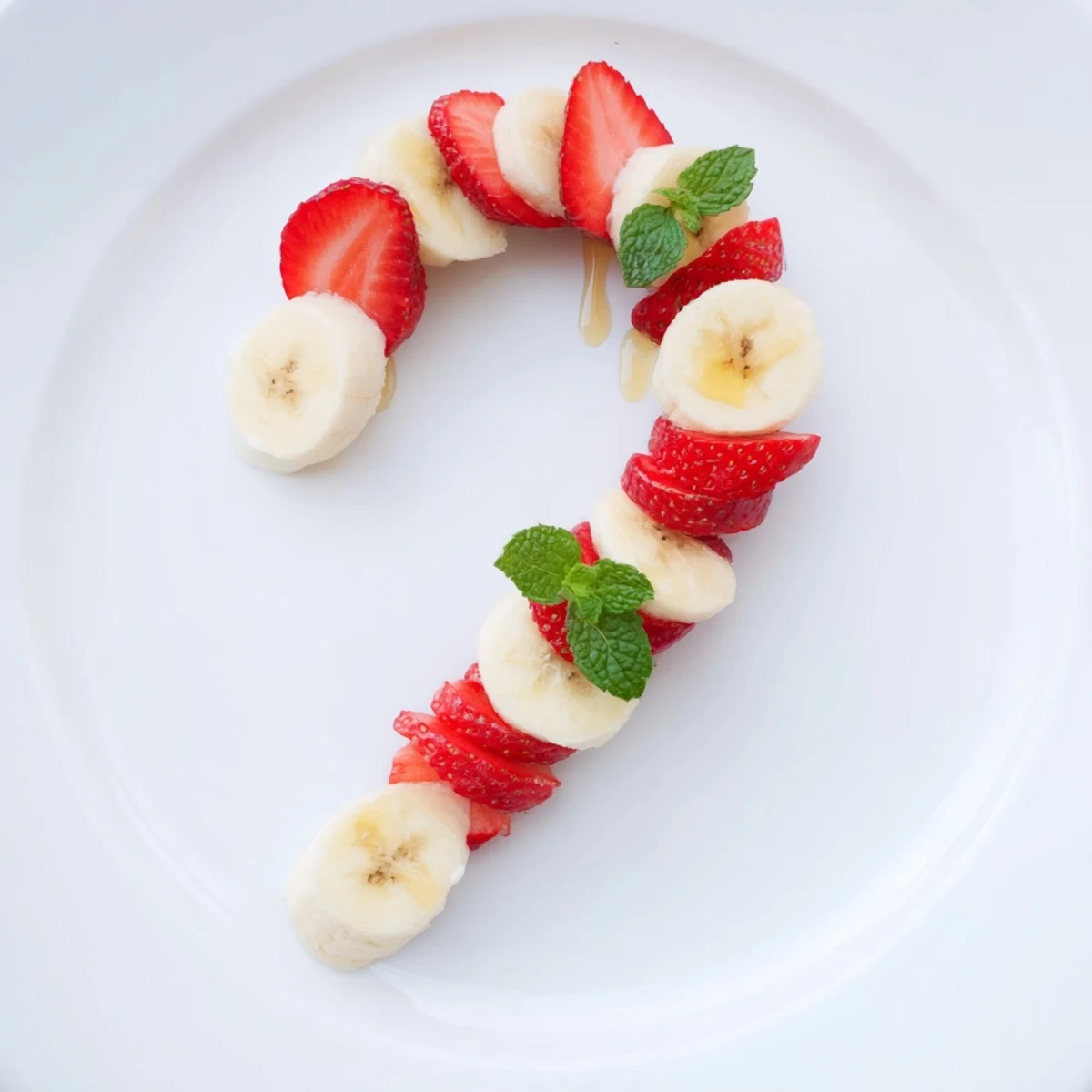 Vibrant photo of a healthy Strawberry Banana Candy Cane; perfect for a holiday treat, with mint garnish.