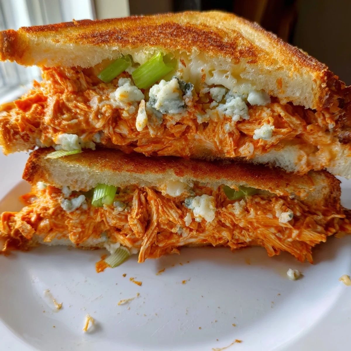 Crispy, toasted sourdough showcases the flavorful fillings of this inviting Buffalo Chicken Grilled Cheese.