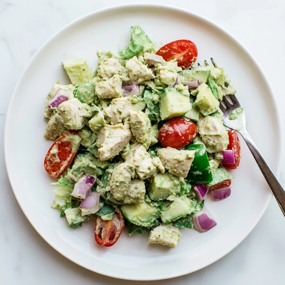 Creamy avocado ranch dressing coats tender grilled chicken chunks, cherry tomatoes, and crisp cucumbers in this refreshing salad.  