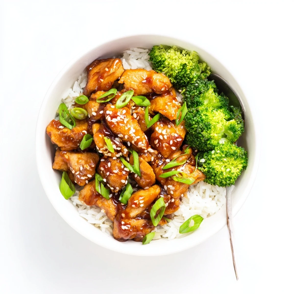 Tender chicken tossed in a glossy sweet chili sauce, paired with crisp broccoli and fluffy rice in a vibrant dinner bowl.