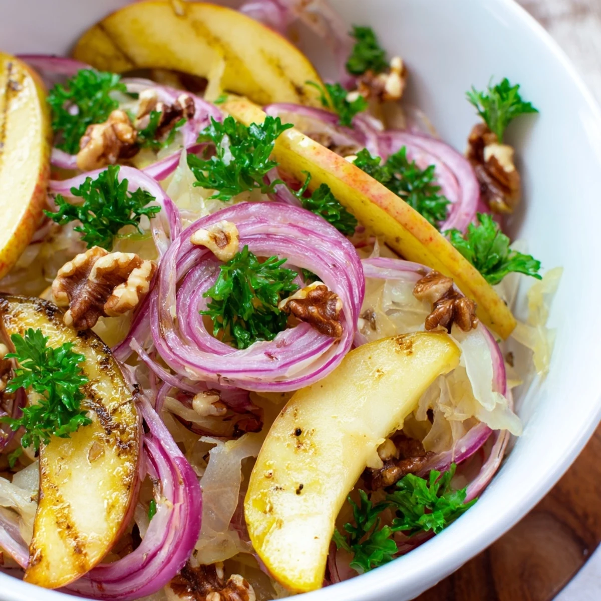 Steamed Warm Apple and Sauerkraut Skillet Salad garnished with fresh parsley and toasted walnuts.  