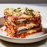 A close-up shot of the mouthwatering Eggplant Parmesan Lasagna, ready for serving after baking.