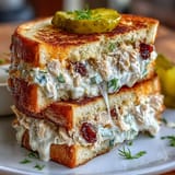 Savory tuna melt sandwich with gooey cheese, crunchy pickles, and buttery grilled bread.  