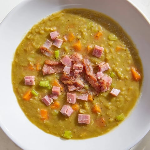 Steaming bowl of Split Pea Soup with canned ham and bacon, garnished with crispy bacon crumbles.