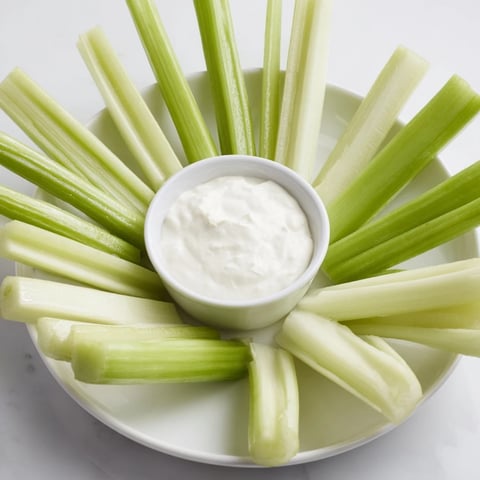 The Rustic Wheel appetizer, boasting crisp celery and meat sticks ready for dipping.