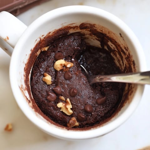 Steaming mug brownie with melted chocolate chips, a quick and easy dessert ready in minutes.