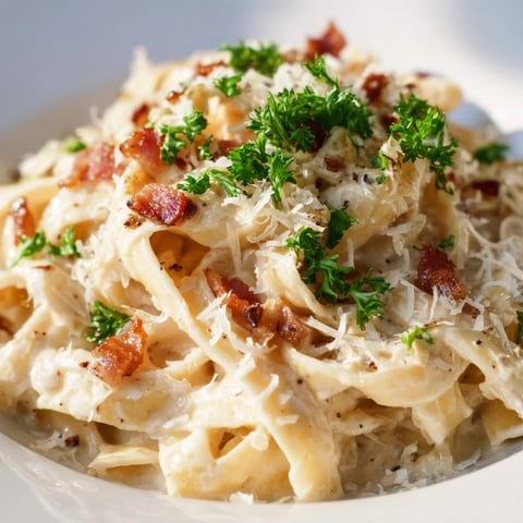 Crispy bacon bits topping a bowl of creamy garlic bacon pasta, ready to eat.