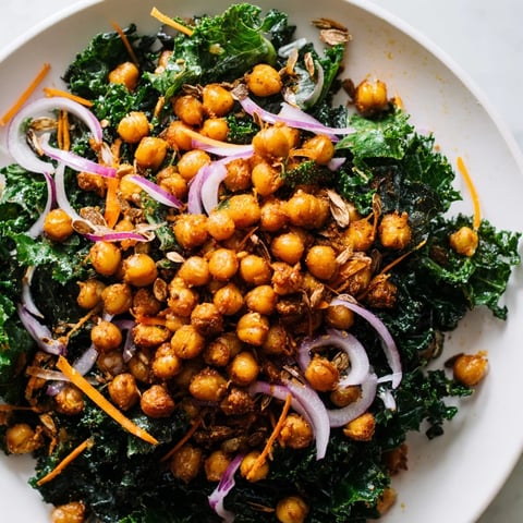 Golden brown, crispy roasted chickpeas topping a fresh Kale Salad, ready to eat.