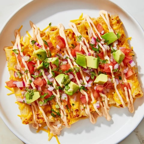 Golden, crispy pasta chips nachos covered in melted cheese, fresh toppings, and vibrant sauce.