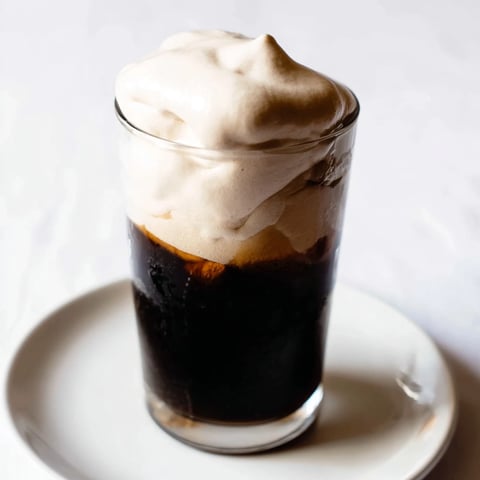 Fluffy Starbucks Cold Foam drizzled over iced coffee, offering a cool, creamy, and flavorful treat.