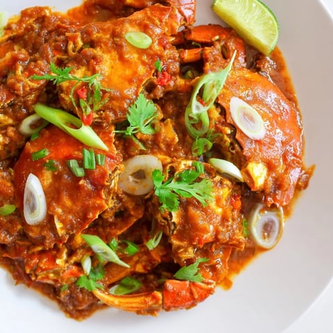 Steaming Singaporean chili crab, covered in a rich, vibrant sauce, ready to be served.