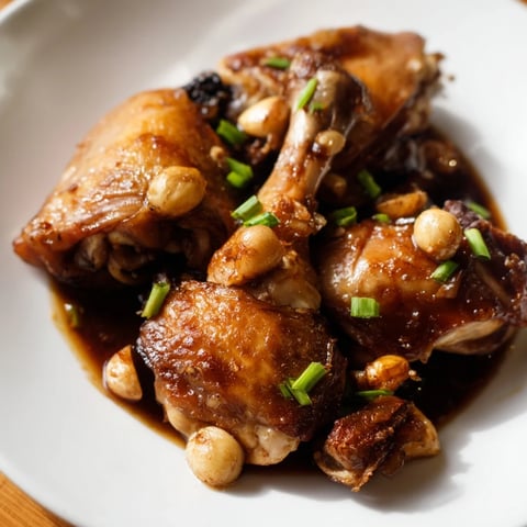 Tender Filipino Chicken Adobo, braised in a savory sauce, beautifully complements fluffy white rice.