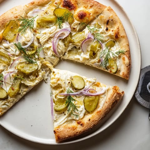 Golden-brown crust of Pickle Pizza, with bubbling mozzarella and fresh dill garnish.  