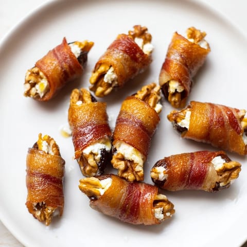 Crispy bacon embracing dates filled with walnuts and cream cheese, a tasty party appetizer.
