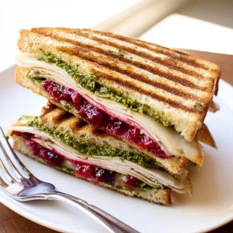A close-up of a perfectly grilled Pesto Cranberry Turkey Grilled Cheese Melt, ready to enjoy.