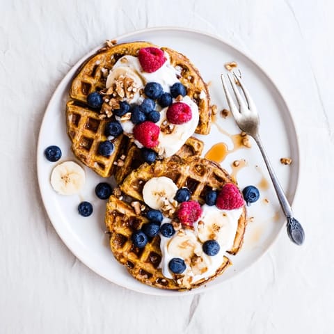 Golden, fluffy Anti-Inflammatory Adaptogenic Turmeric Waffles fresh from the iron, perfect with fresh berries and a drizzle of maple syrup.