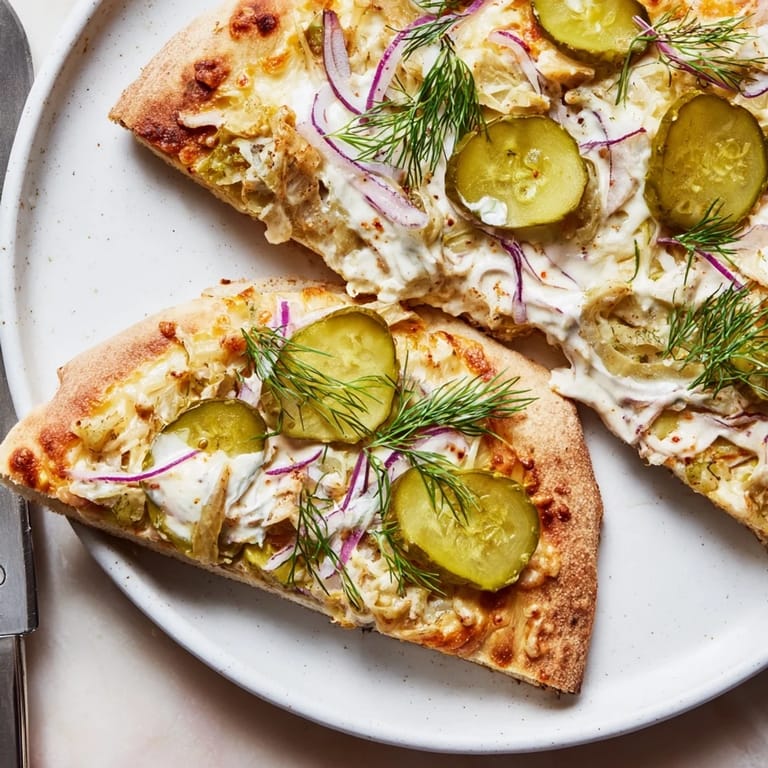 Slice of unique Pickle Pizza, featuring a rich crème fraîche and vibrant toppings.