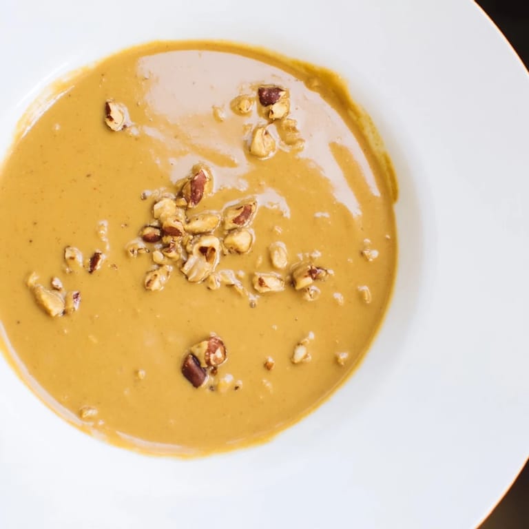 Vibrant photo capturing the rich flavors of Indonesian satay sauce, thick and ready to dip, complete with a savory aroma.