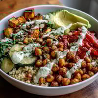 Close-up of the finished Chickpea Power Bowl, featuring spiced chickpeas, roasted vegetables, and a creamy tahini drizzle.
