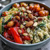 Vibrant Veggie and Quinoa Power Bowl with roasted vegetables, beans, nuts, and a zesty lemon vinaigrette on a rustic table. 