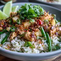 Coconut Pineapple Chicken Rice Bowls with juicy chicken, tropical pineapple, and creamy coconut rice, garnished with fresh herbs and lime wedges.